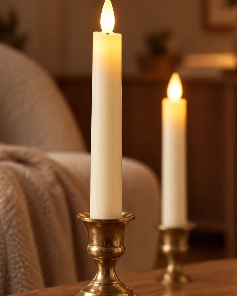 Flameless LED taper candle in a brass holder beside an armchair