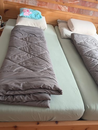 Two grey Wove duvets side by side on two mattresses in a timber cottage