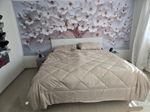 Sand-coloured Wove duvet on a large bed in a guest room with floral wallpaper
