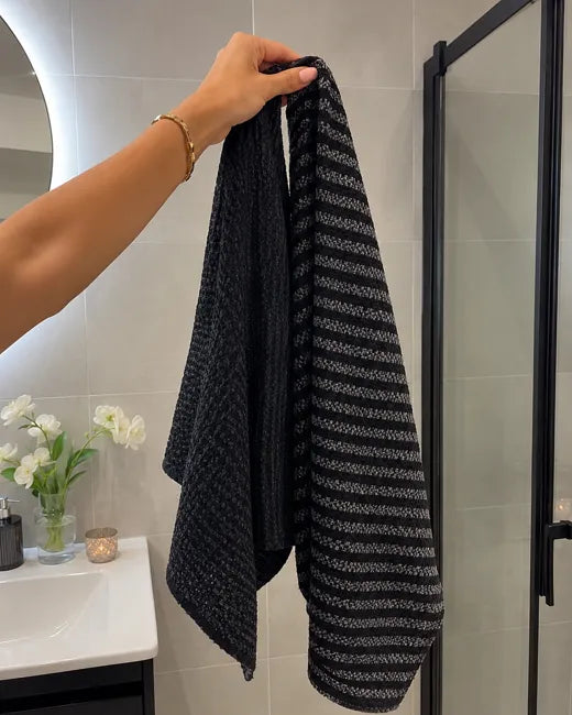 Two Wove towels hanging on the shower screen