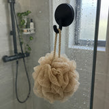 Black Wove hook on a glass shower screen with a beige sponge