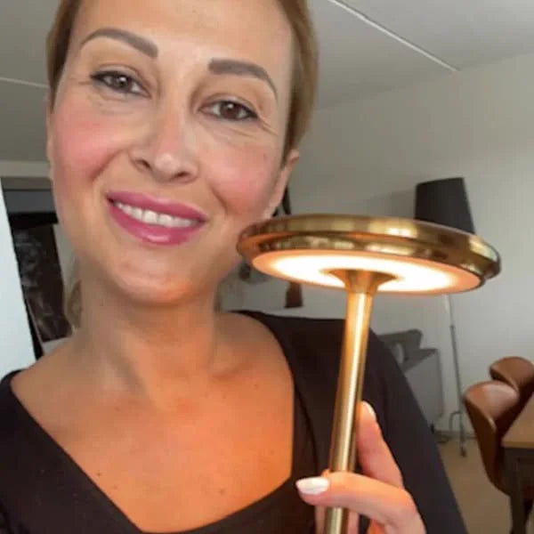 Customer holding up the Copenhagen lamp in gold